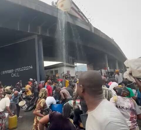 Residents scoop fuel as a diesel tanker falls at Tincan Liverpool Bridge
