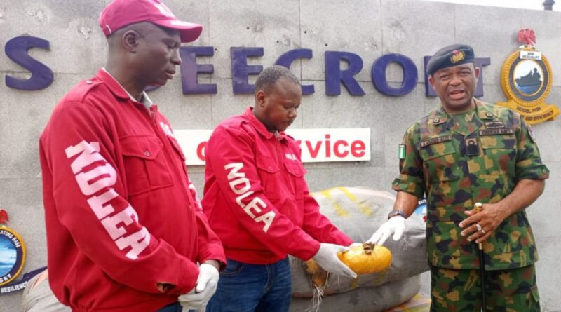 From l- DCN Adejumo Gbenga, NDLEA official and Commander NNS Beecroft, Commodore Aiwiyor Adams-Aliu , displaying a pack of the seized cannabis, during a press briefing at the NNS Beecroft parade ground, Apapa, Lagos.
