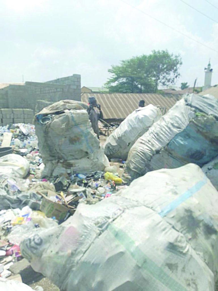 Across major roads and narrow inner streets, heaps of refuse spill from makeshift dumpsites onto the roadside. Black nylon bags burst open